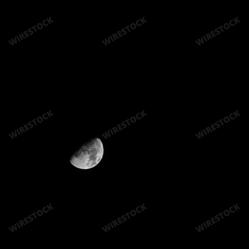 The beautiful grey half moon in the pitch black dark sky