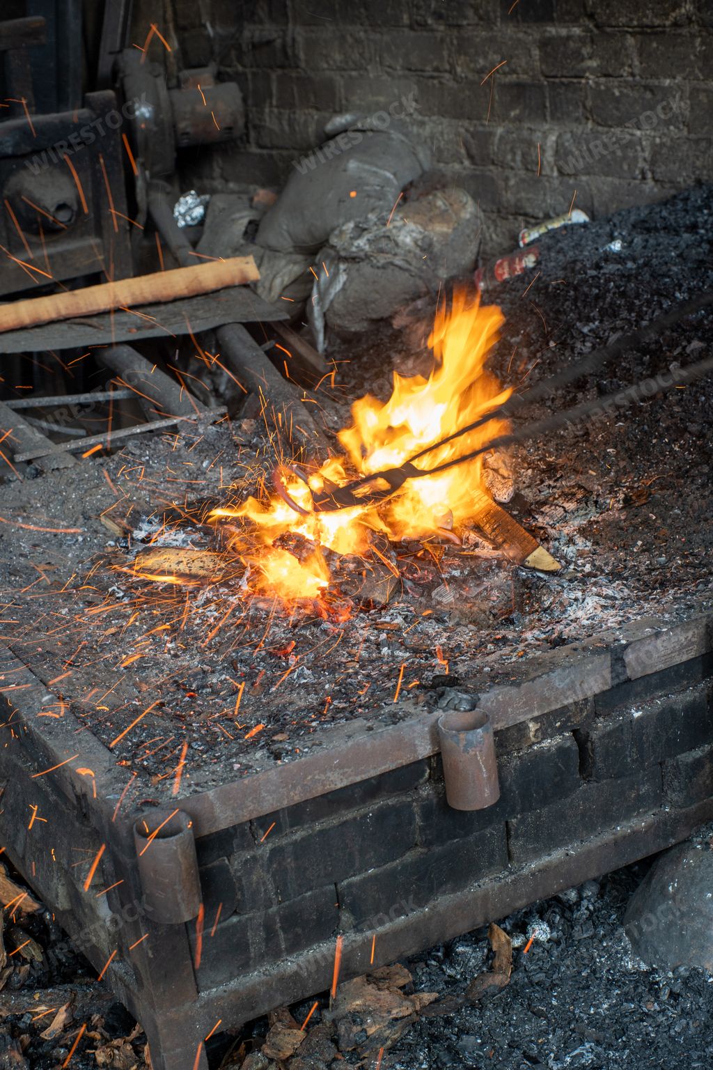 A vertical shot of tools and accessories of the ancient blacksmith forge with air fur blowing