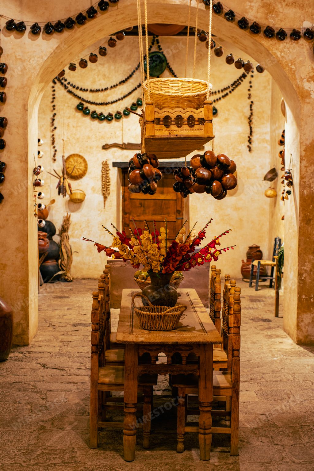 A vertical interior shot of a traditional Mexican house with a wooden table and chairs.