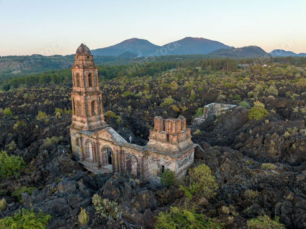 The ruins at Paricutin Volcano situated on a rocky landscape surrounded by lush greenery