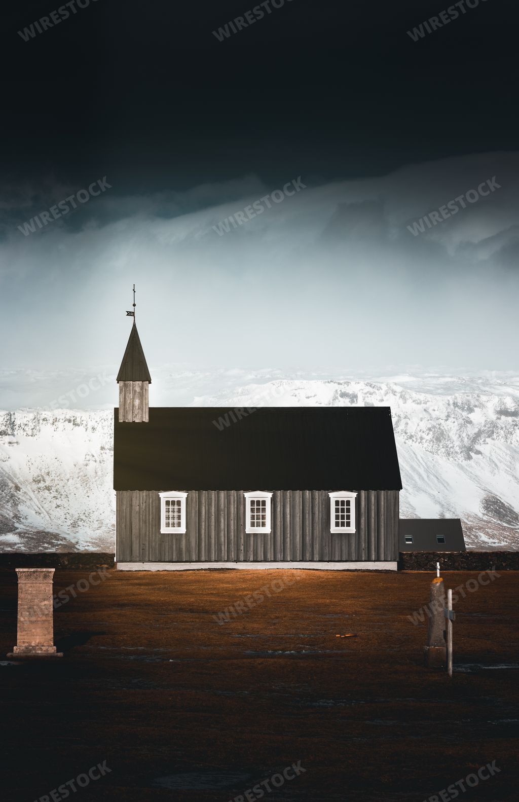 A vertical shot of the Budakirkja church in winter under a gloomy sky in Iceland