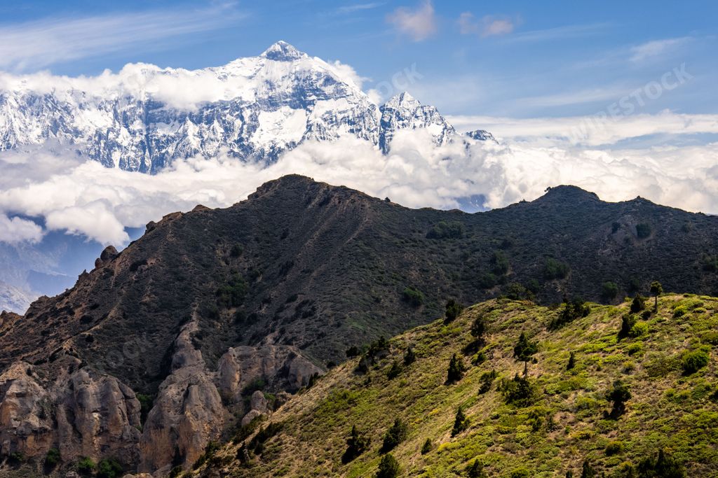 A view of the snowy, green, shadowed Annapurna and Nilgiri mountains in the Kingdom of Mustang