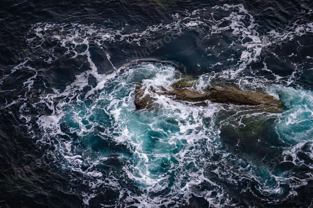 The deep blue water surface with a rock.  Mealt Falls, Isle of Skye, Scotland, UK.