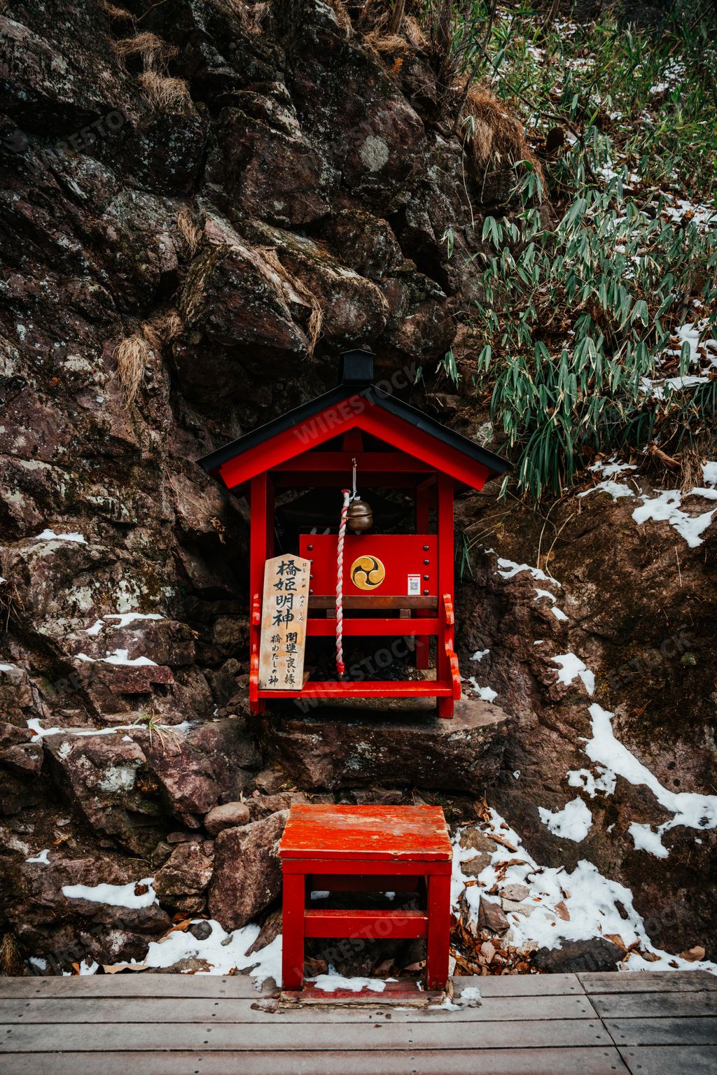 Stunning winter snow shot of the shrine near the romantic red sacred Shinkyo bridge at the entrance to Nikko’s shrines in Nikko Japan