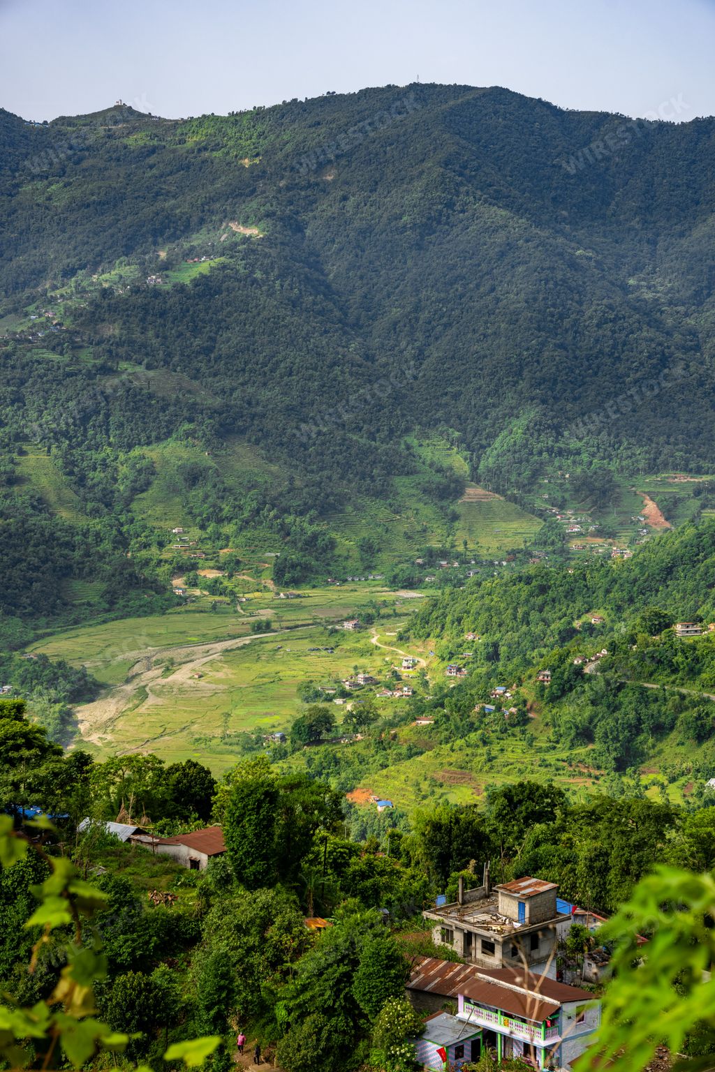 A vertical aerial view of green Pokhara city among the mountains in Nepal.