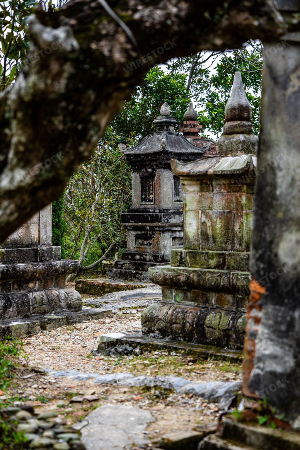 A vertical shot of an Asian Buddhist Temple and Shrine in Northeast Vietnam with Mountains in the Background.