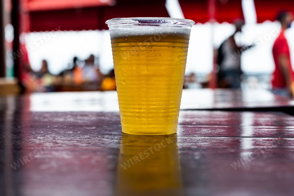 Plastic cup with beer inside to be drunk. Sao Joaquim Fair, Salvador, Bahia, Brazil.