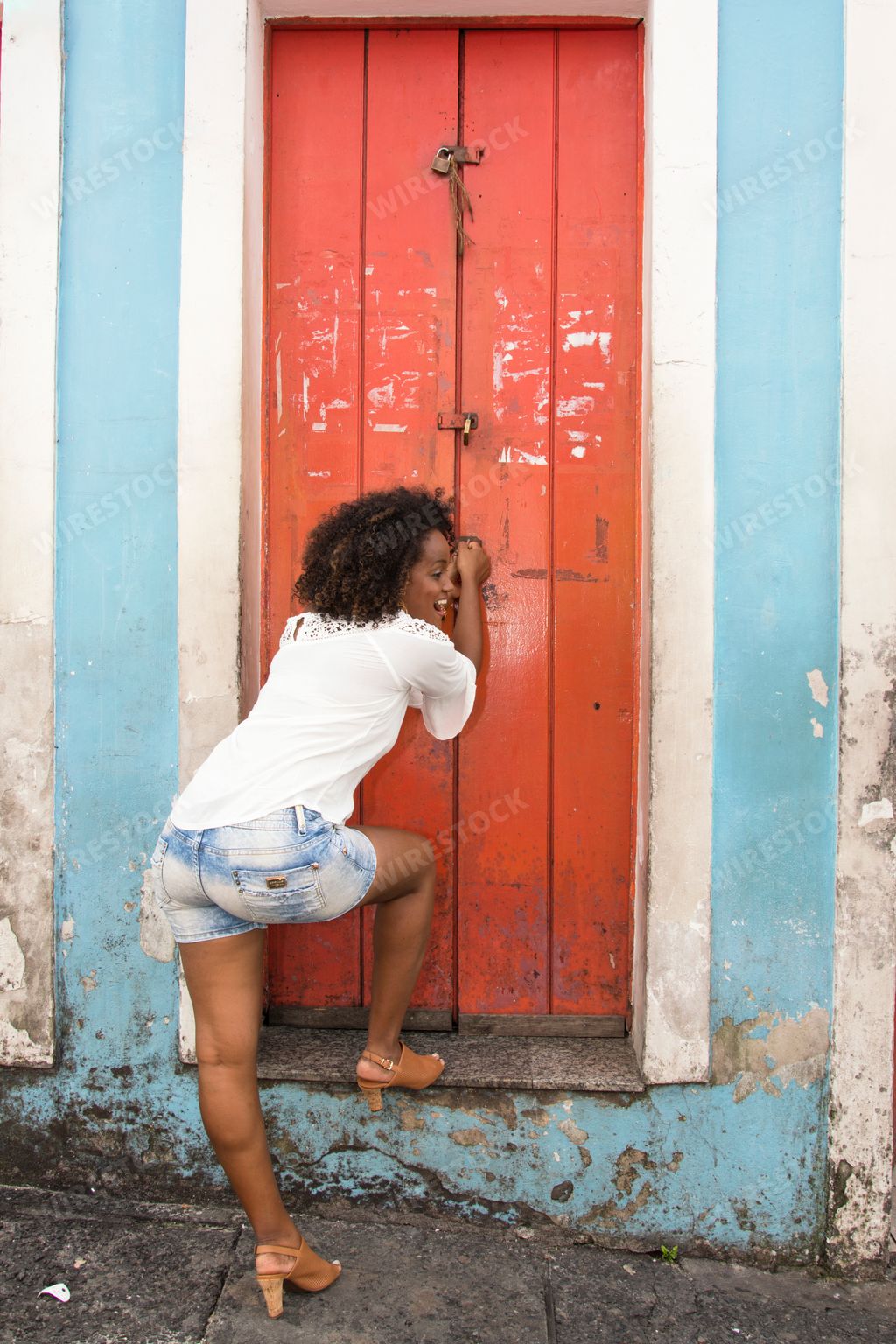 A beautiful Brazilian girl posing near a red door in Salvador, Brazil