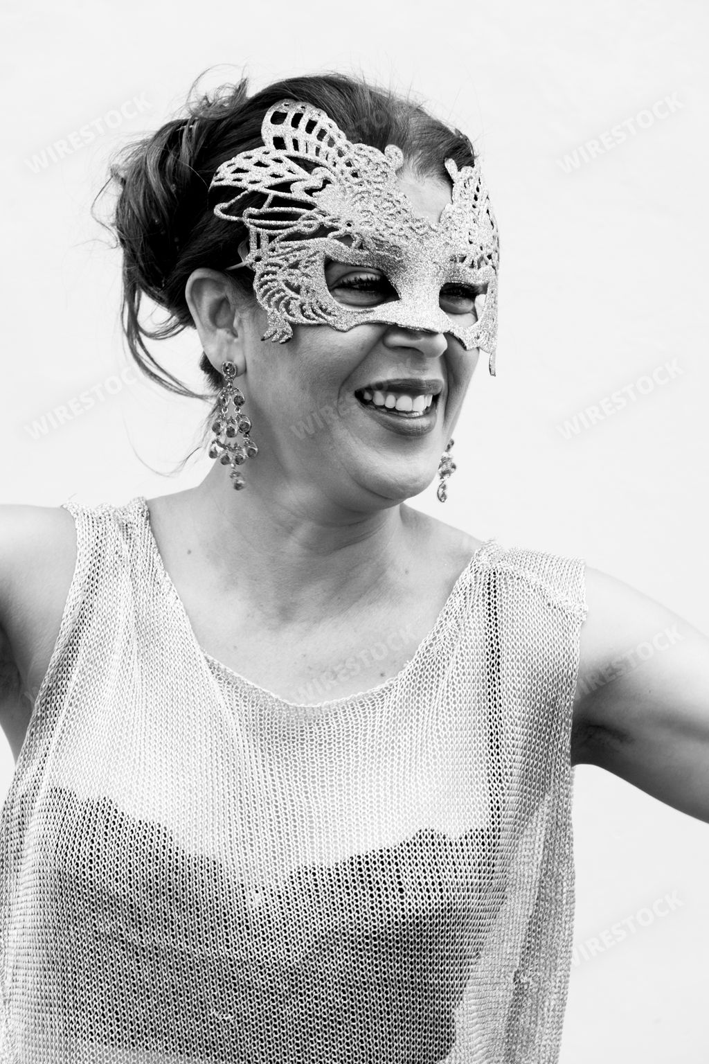 A Brazilian woman wearing Venice Carnival mask against a wall background in Brazil