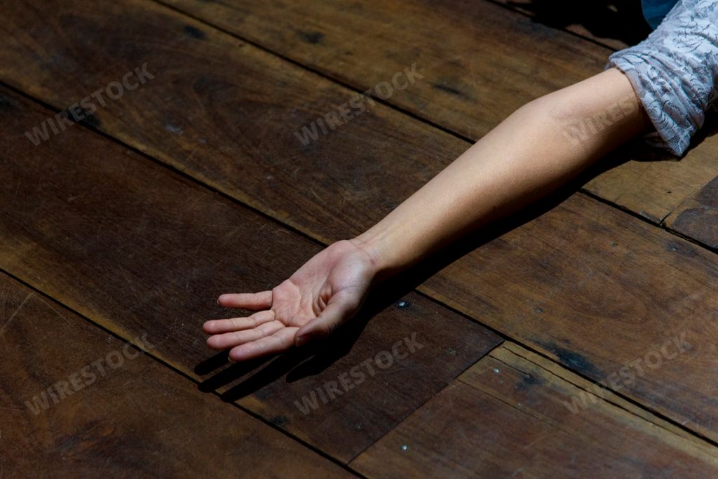 An actress lying and stretching her arm on the wooden floor of 
a stage in Salvador, Bahia, Brazil.