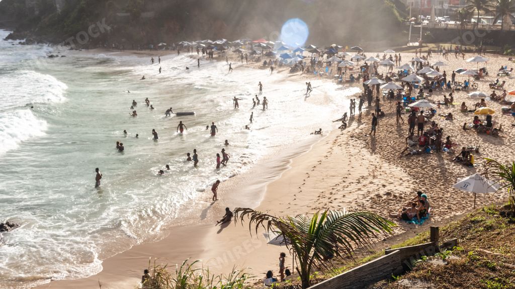 A silhouette of people swimming in the sea on Paciencia beach on a sunny day