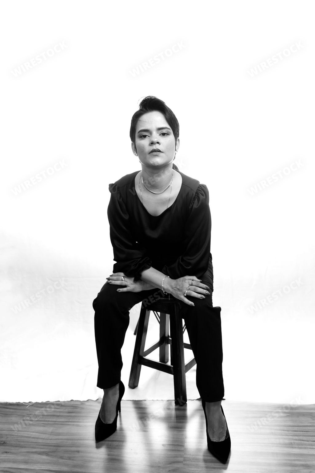 A black and white portrait of an attractive female seated in a chair