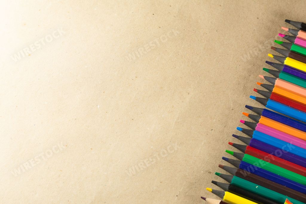 A vibrant assortment of colored pencils laid out on a wooden table