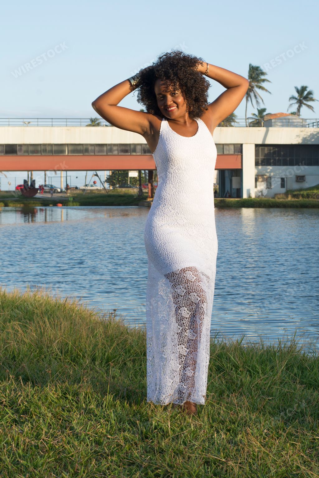 A beautiful black female model in a white dress posed by a river in Bahia, Salvador, Brazil