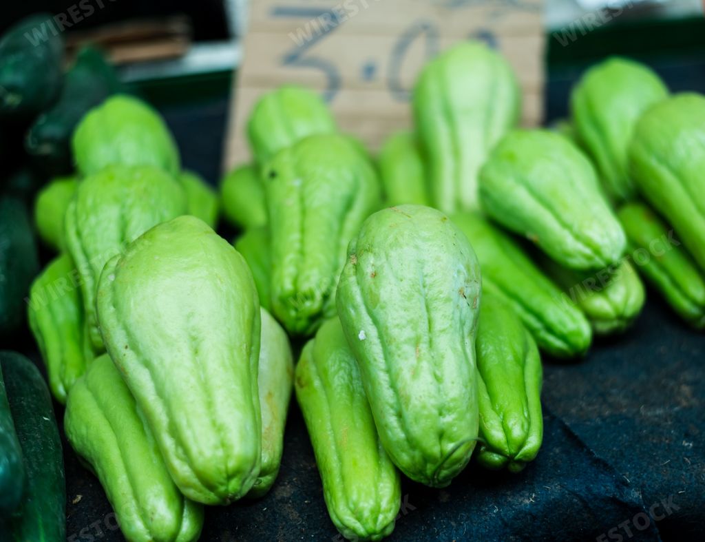 A pile of fresh chayote squash for sale at a local market