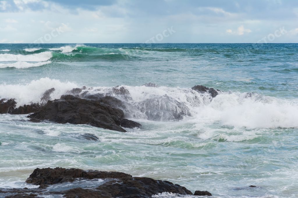 A dramatic big waves splashing over rocks and cliffs during a stormy day