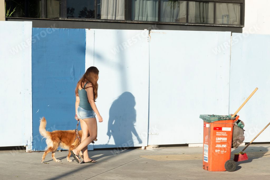 A view of the female walking with her dog in the street in Salvador, Bahia, Brazil