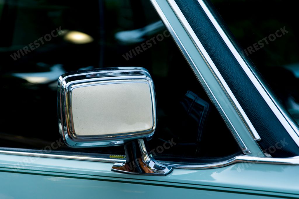 A close-up shot of a cyan-colored vintage retro luxury car side-view mirror detail