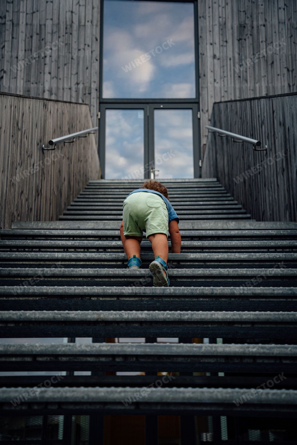 A kid is climbing up the stairs to reach his goal