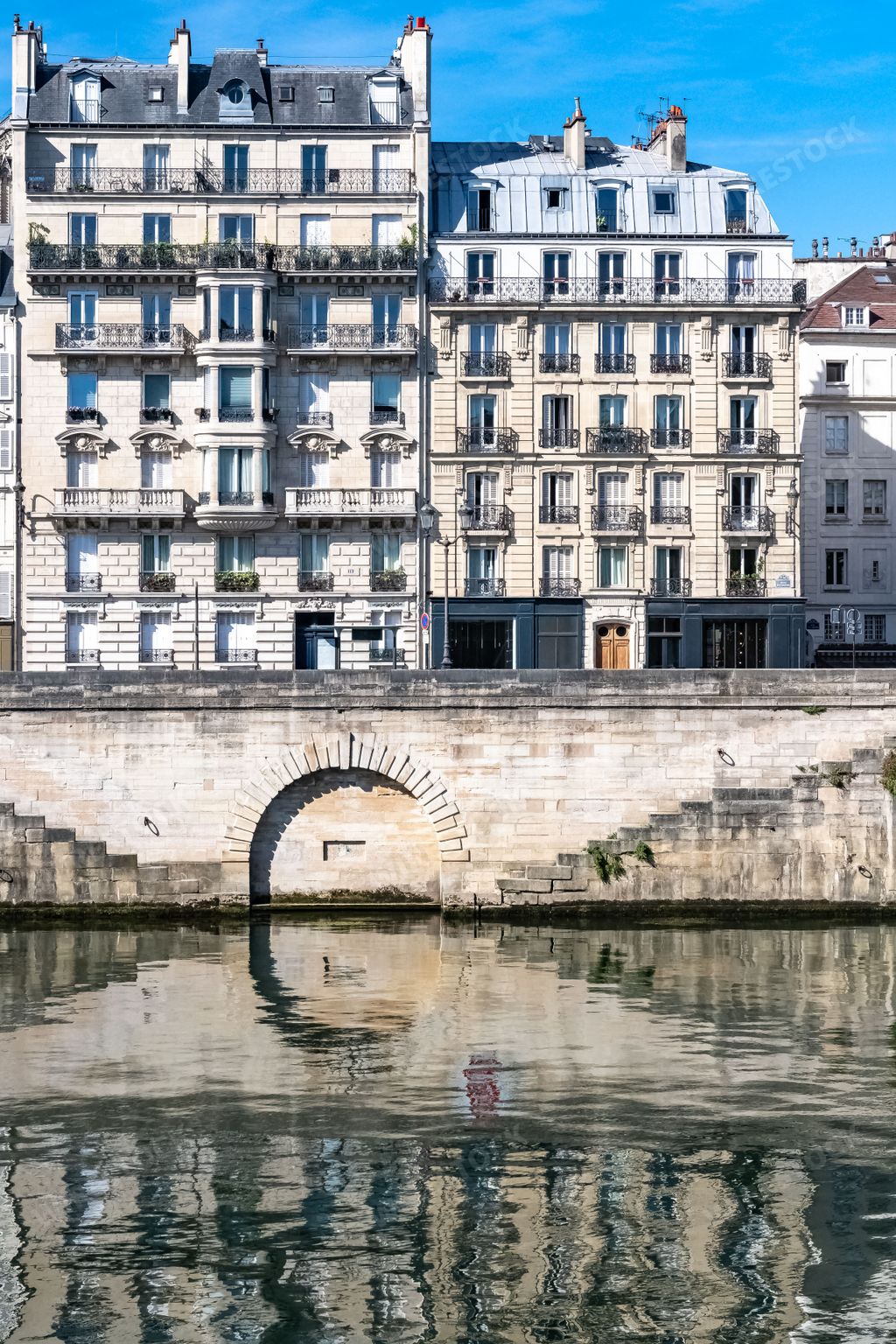 Paris, ile saint-louis and quai aux Fleurs, beautiful ancient buildings, with reflection on the Seine in summer