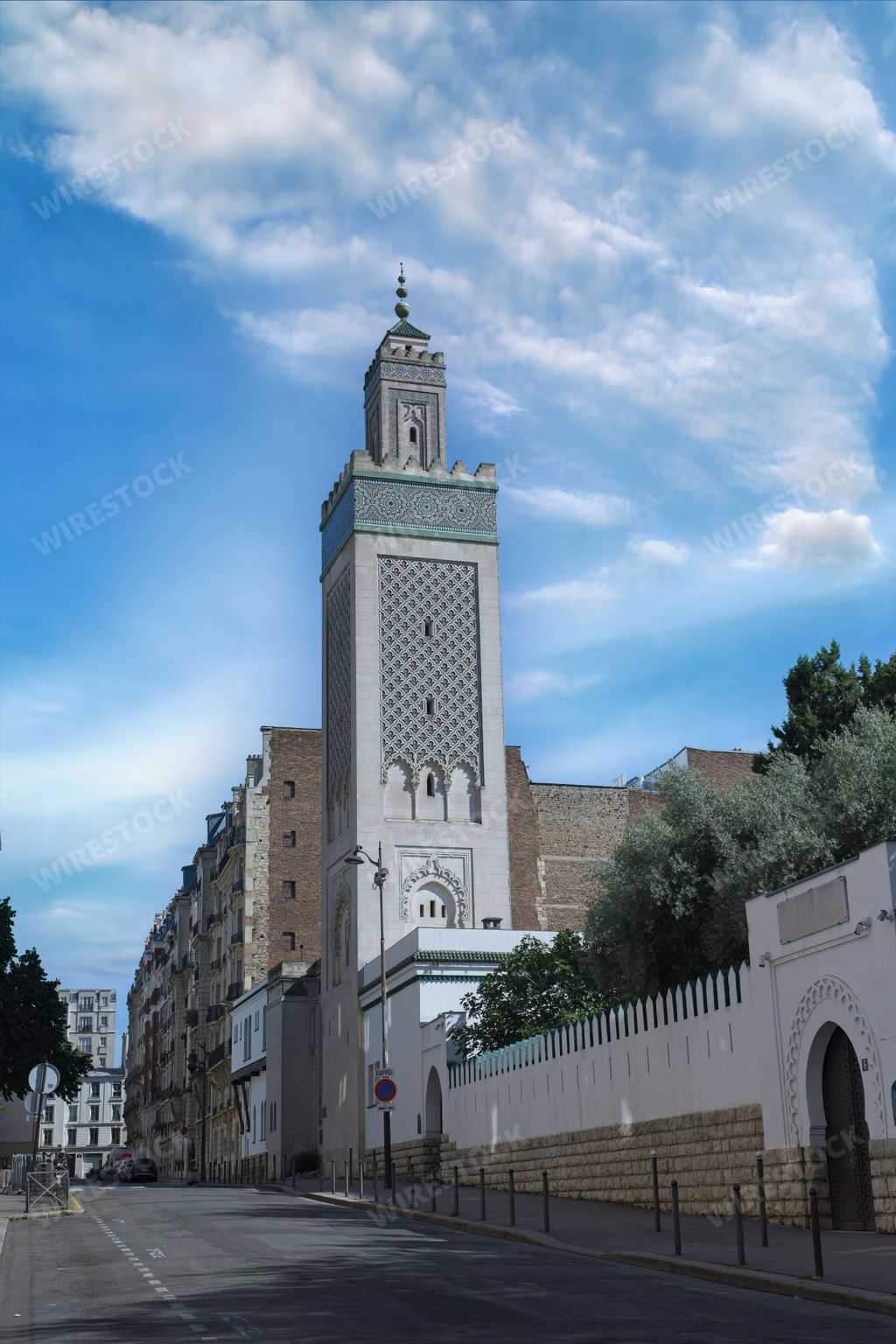 A clear day view of the Grand Mosque of Paris with its intricate architecture and a blue sky background.