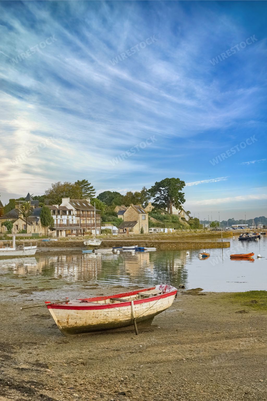 A vertical shot of an old rowboat on the shore of Ile aux Moines island in the Morbihan gulf