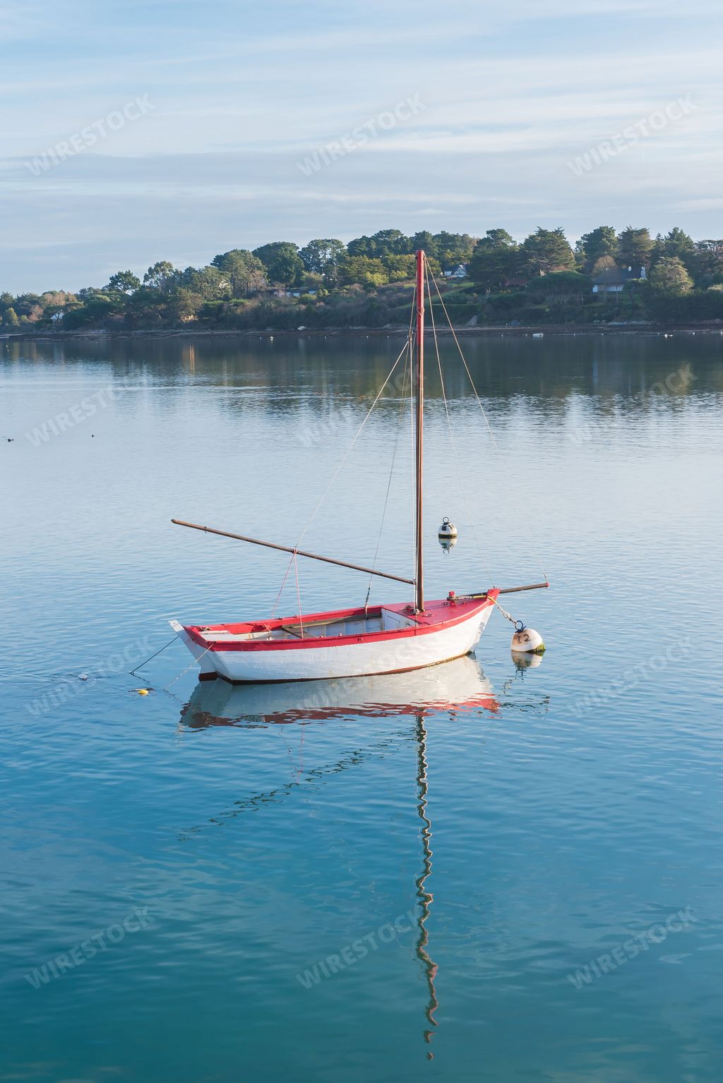 Rowboat, white and red boat and buoys in Brittany, on a glassy sea, with the Morbihan gulf in background