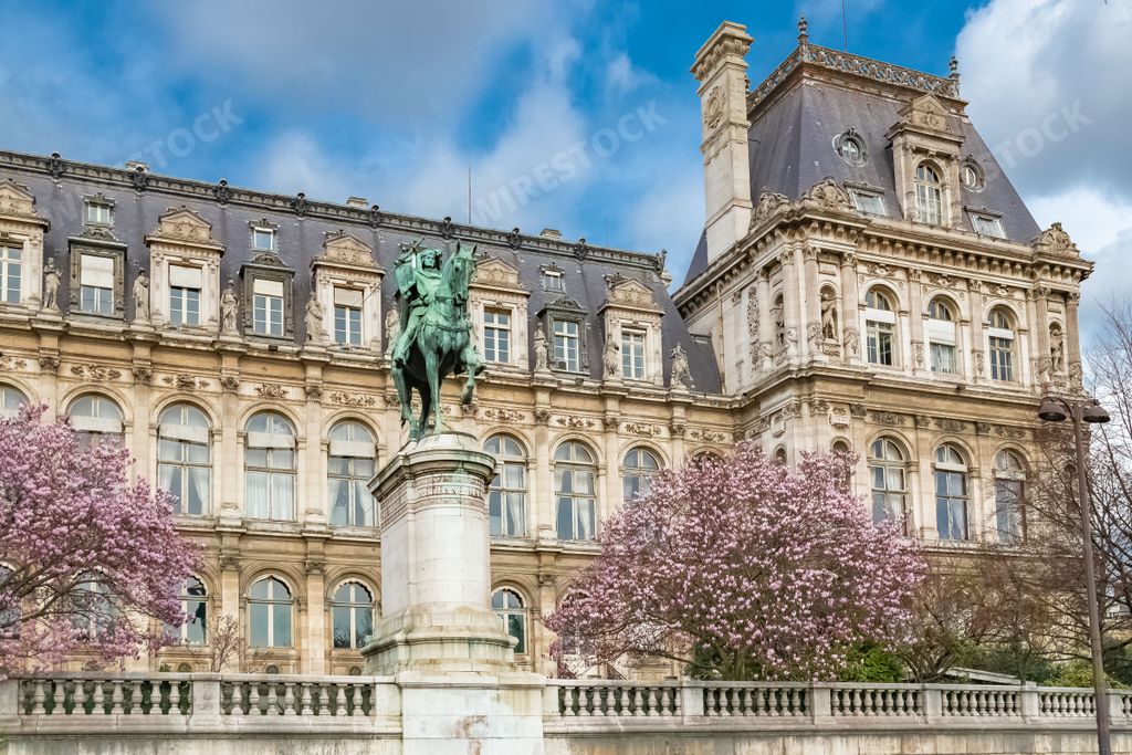 Paris, the facade of the Hotel de Ville, city hall of the French capital, with cherry trees in flower