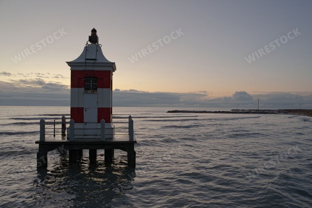 A pier with a lighthouse during a calm evening