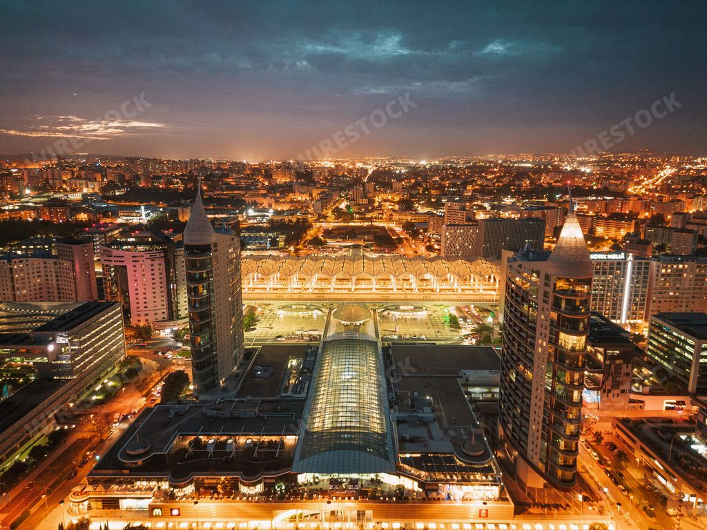 A stunning nighttime view of high-rise buildings, illuminated by the golden lights of the cityscape in the background