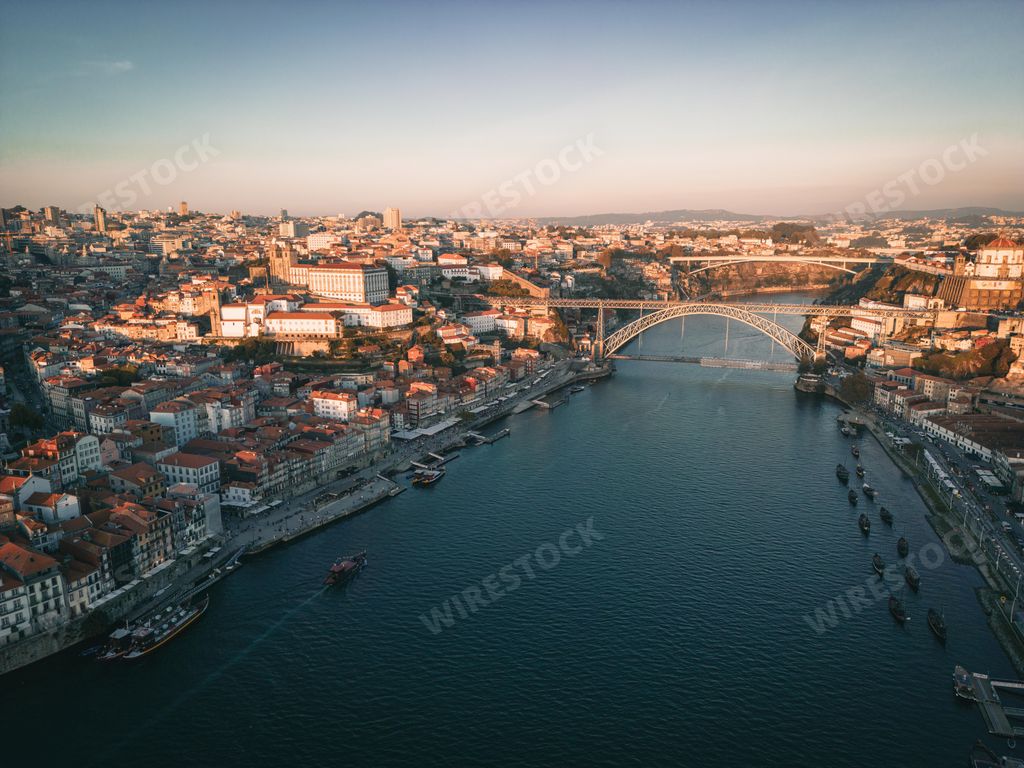 A bird's eye view of the Douro river flowing through Porto, Portugal at sunset
