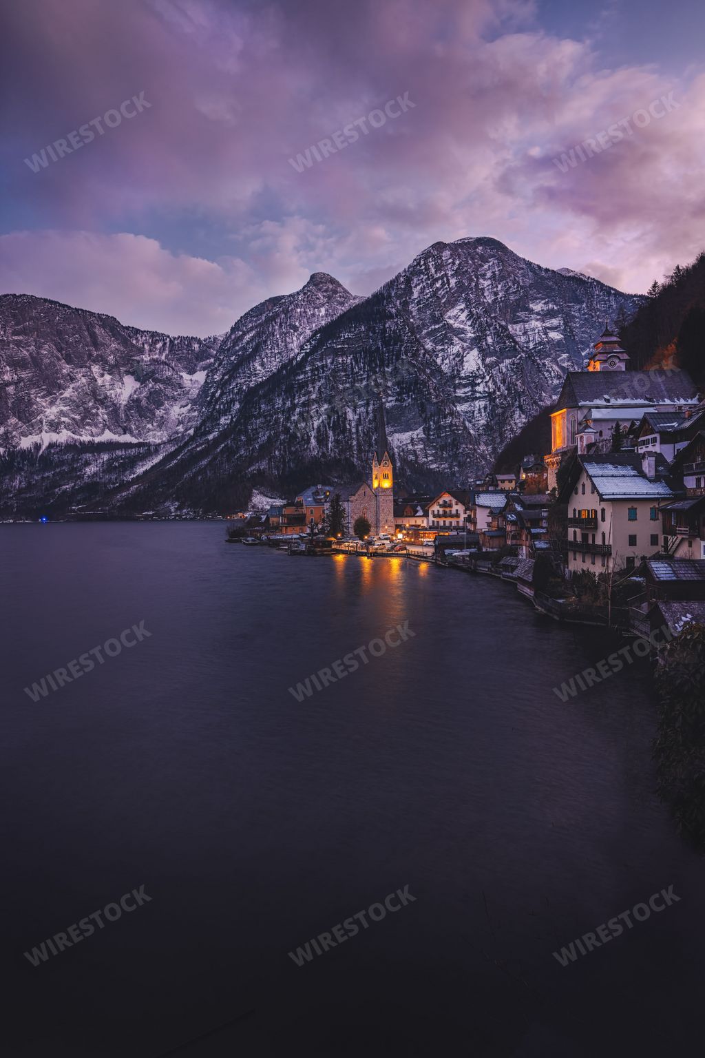 A clear lake in Austria with a village and mountain landscape
