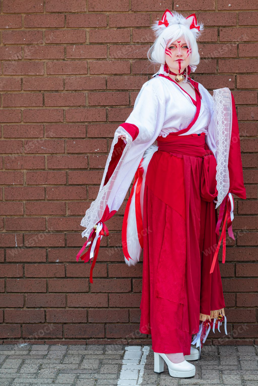 Female cosplayer in feline priestess attire at a convention