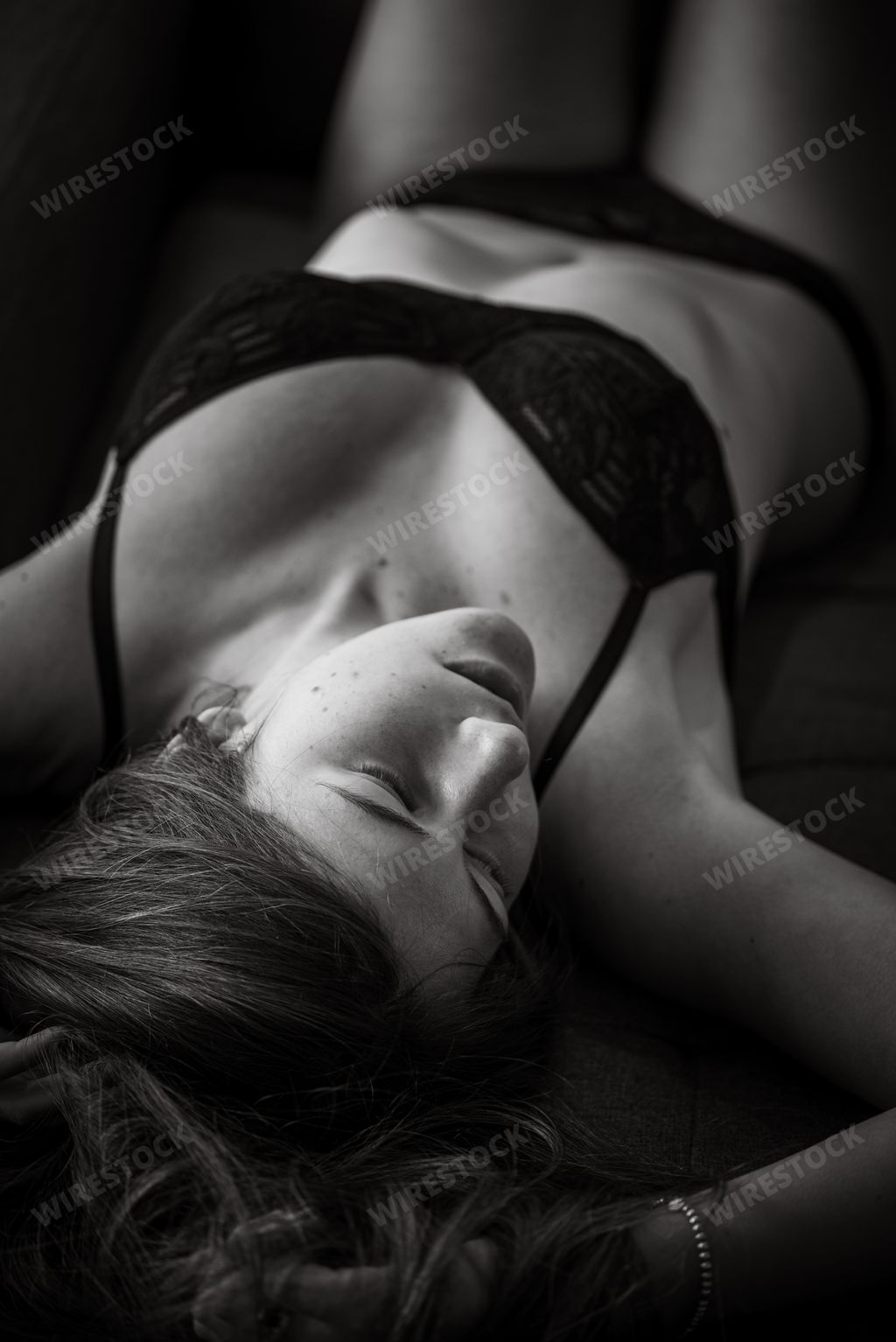 A woman in a bikini lies on her stomach, eyes closed
