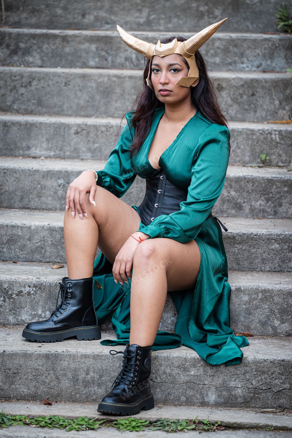 A young female cosplayer is dressed in a costume depicting Loki, a popular Marvel Comics character