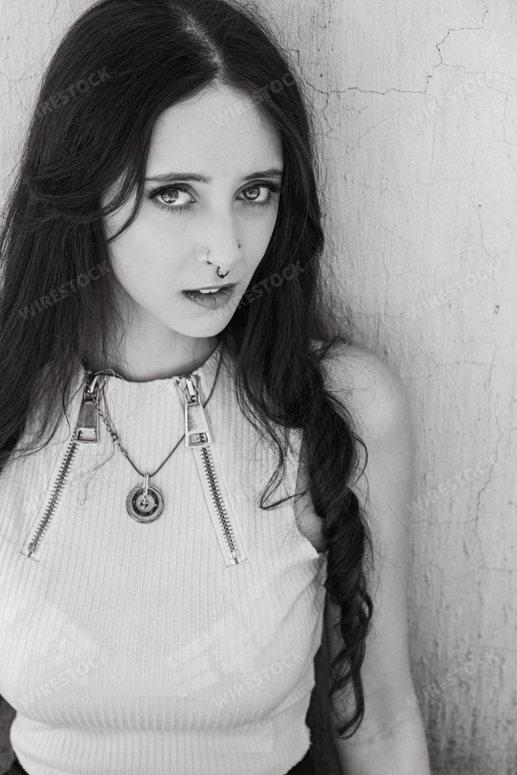 A grayscale shot of a goth girl in an urban setting