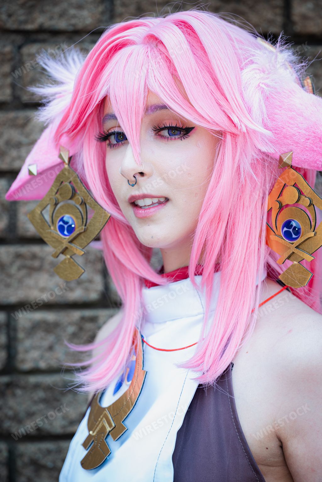 A Female cosplayer in a pink anime costume wearing pink hair