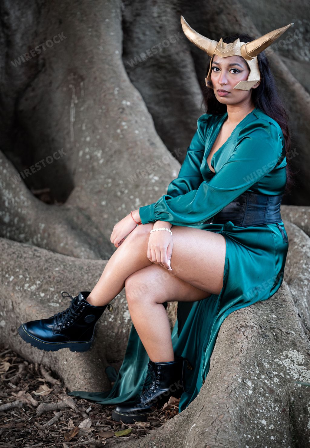 A young female cosplayer is dressed in a costume depicting Loki, a popular Marvel Comics character