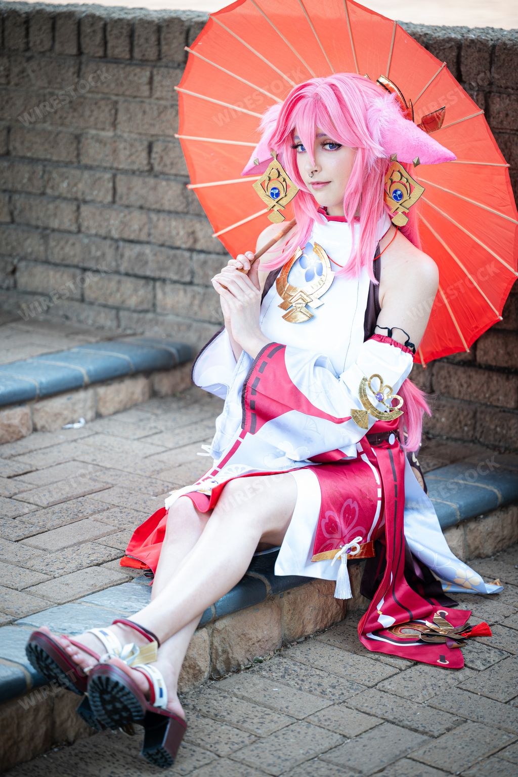 A Female cosplayer in a pink anime costume wearing pink hair