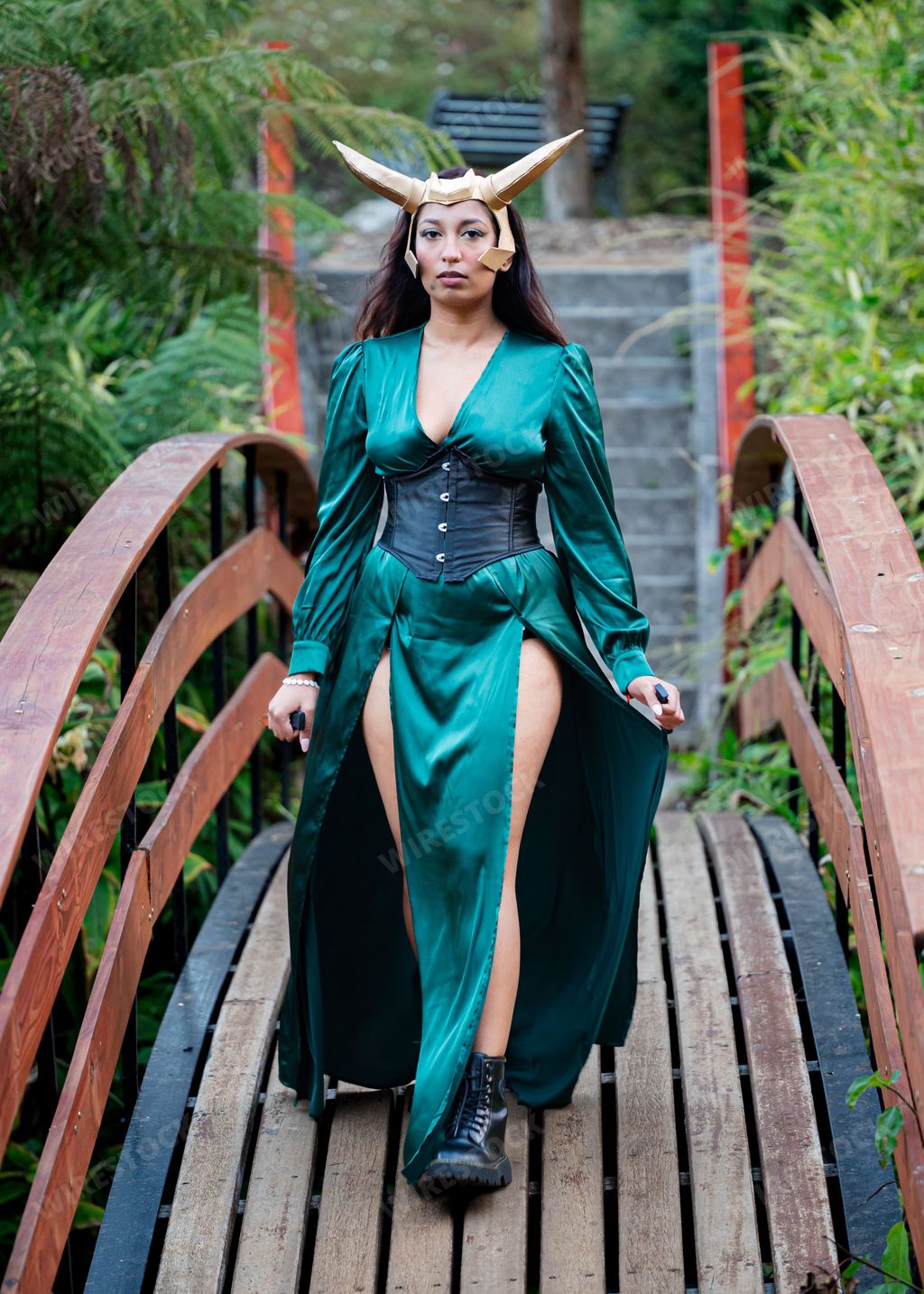 A young female cosplayer is dressed in a costume depicting Loki, a popular Marvel Comics character