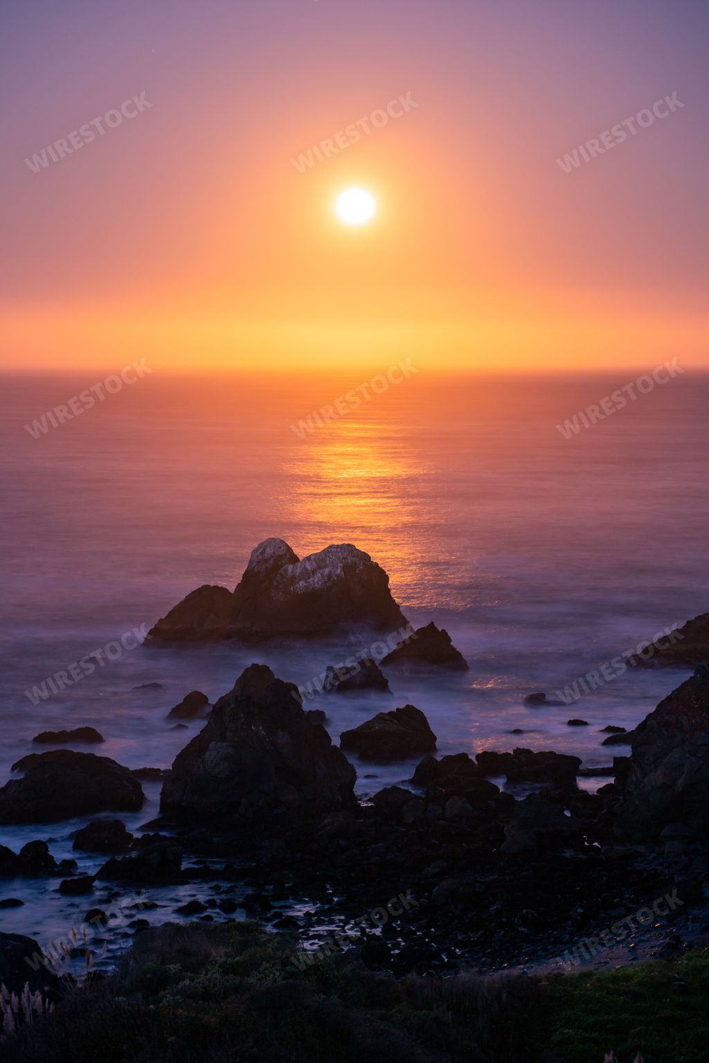 A long exposure shot of the Harvest Moon illuminated by the coming sunrise at Bodega Bay California,