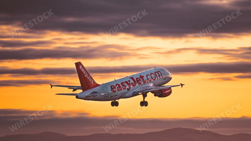An easyJet airplane a320 flying in the sky at sunset