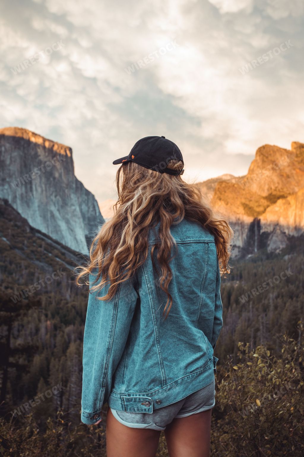 A young female with blonde hair standing in front of a tunnel view in Yosemite National Park.