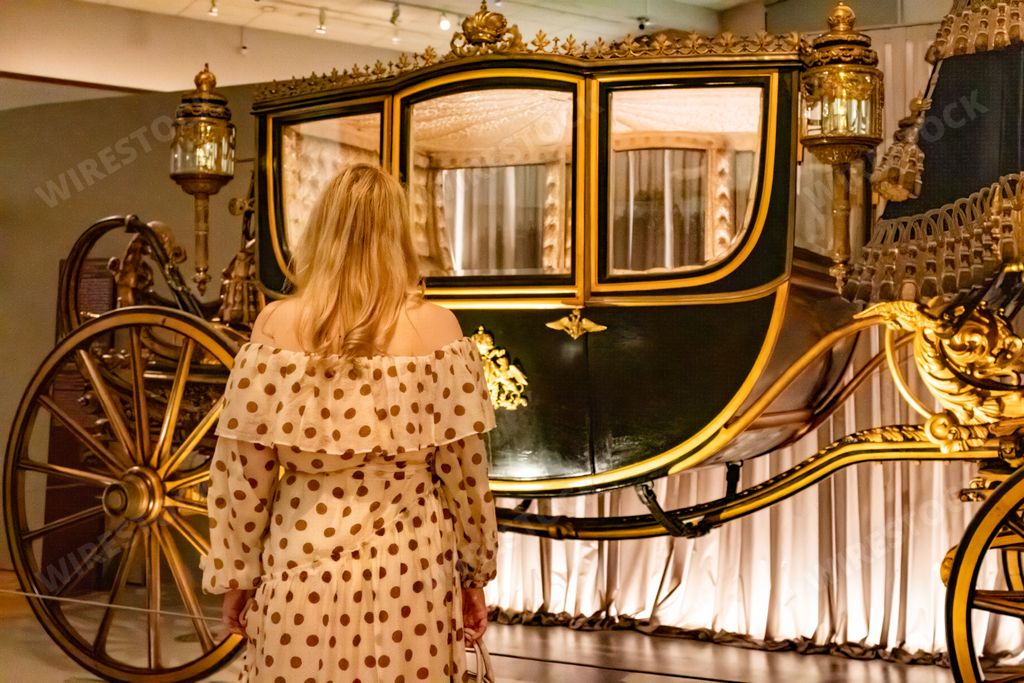A back view of a female watching classical carriage in Carriage Museum from Schonbrunn Palace, VIenna