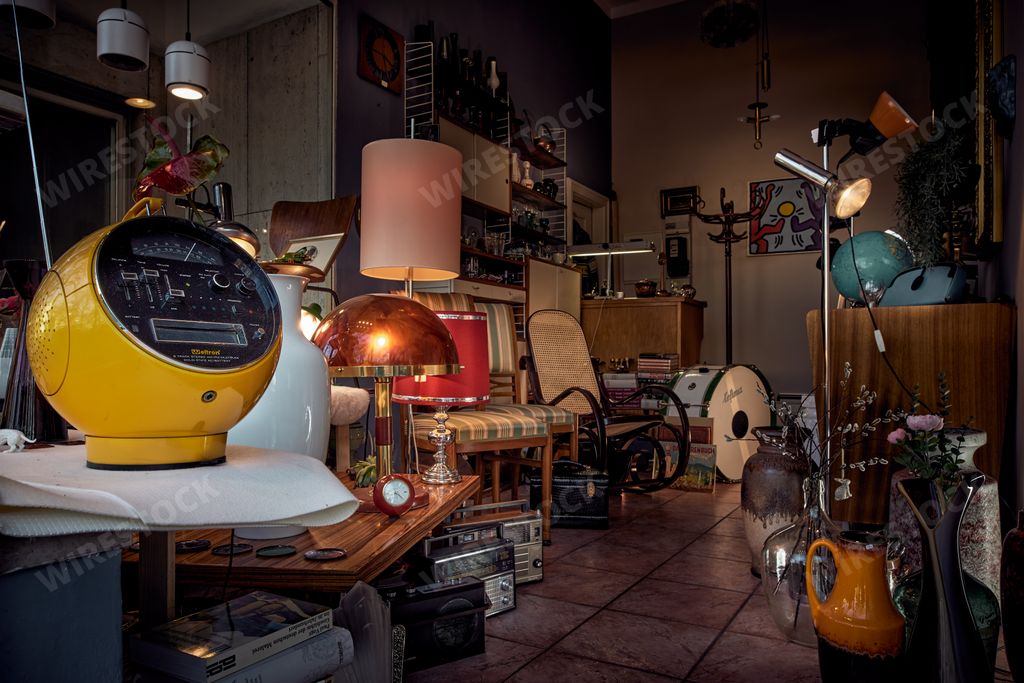 A beautiful Tiny vintage shop in Munich with yellow vintage radio in foreground, lights and classic chair
