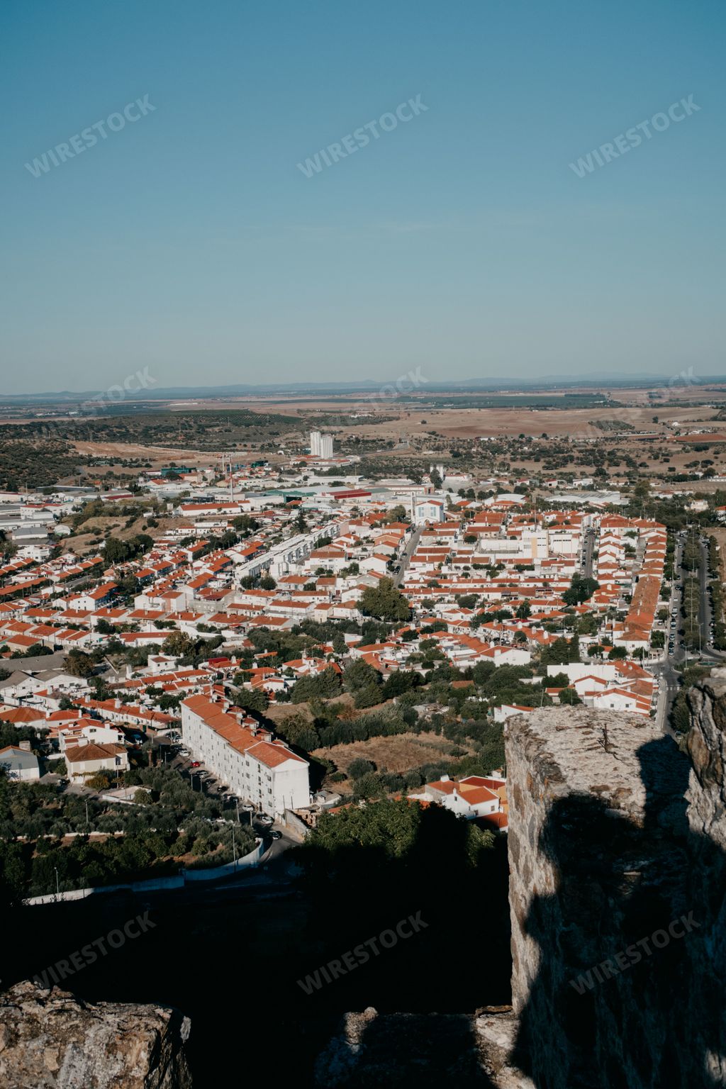 A high angle view of residential buildings with orange roofs on a sunny day