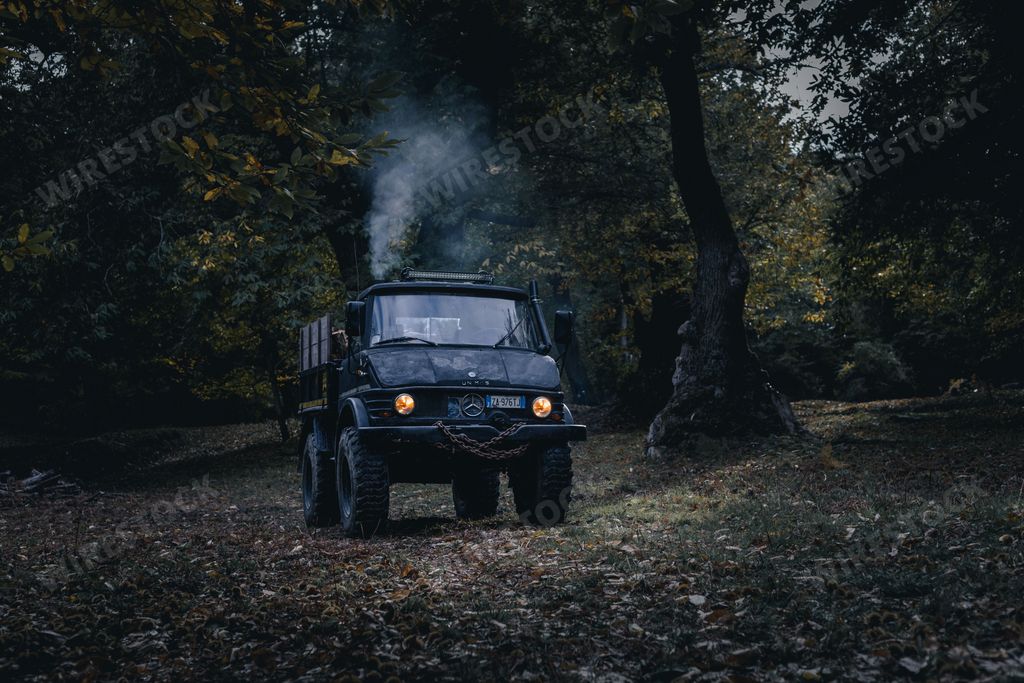 An off-road black car driving in the dark forest
