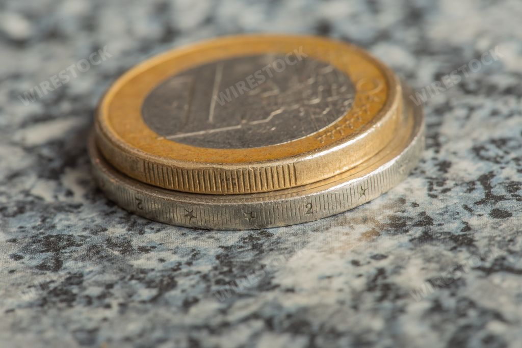 A closeup shot of euro coins stacked on each other on a blurred background