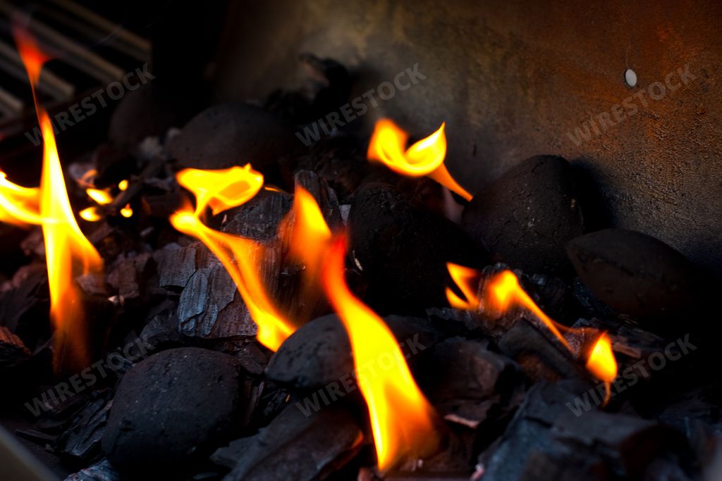 Black charcoal burning in a metal container