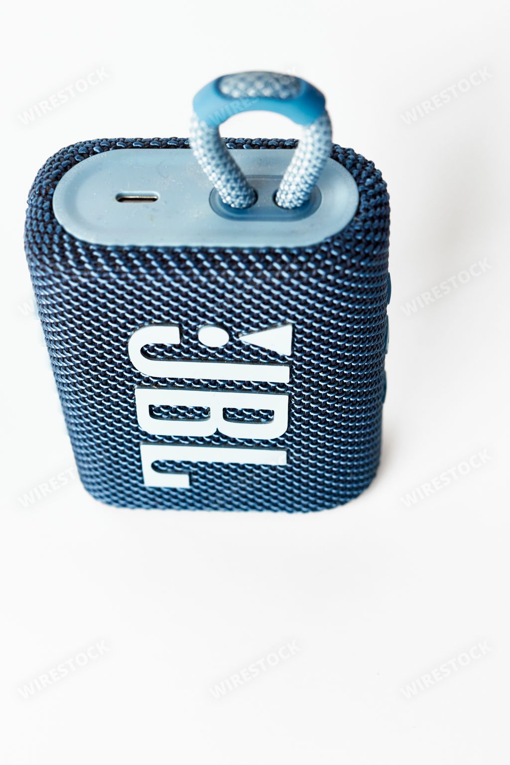 A blue jbl go 3 speaker on a white background